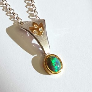 This Semi-Black Opal pendant features a captivating blue-green Opal set in a unique design of pure precious metals, accented with sparkling diamonds